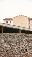 Muro de piedra junto a edificio con vertanas