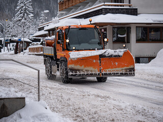 Road Vehicle Snowplow in action on Whitewashed Roads During a Snowy Day