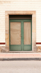 Puerta de tienda clausurada en fachada de baldosas blancas