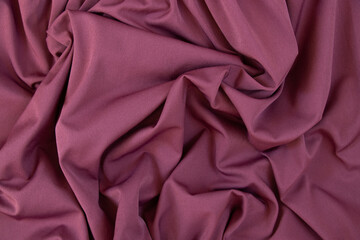 Texture of pink fabric. Background with folds. Close-up.