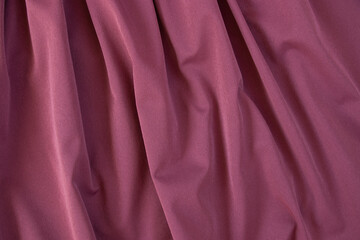 Texture of pink fabric. Background with folds. Close-up.