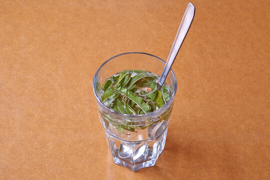 Glass Of Vervain Tea On Brown Wooden Table