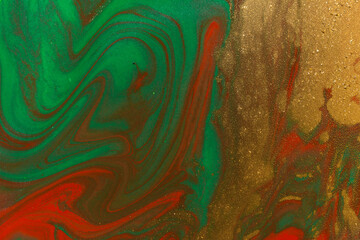 Gold spots on flow red and green paints background. Abstract print