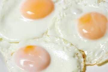 Close-up scrambled eggs. Three fried eggs on a plate. Quick and tasty breakfast