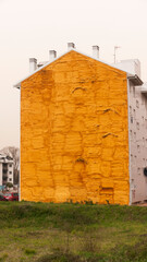 Fototapeta na wymiar silueta de casa con pared medianera pintada de espuma aislante dorada