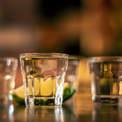 vodka shots on wooden table closeup square
