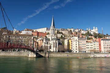 Panorama of old lyon in France with in the foreground the river Saône, the Saint George church, the Saint George footbridge , and the basilica Notre Dame de fourvière on the heights at sunrise.