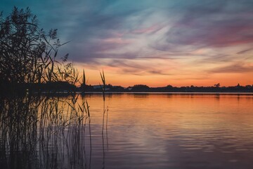 Naklejka na ściany i meble Beautiful colorful morning landscape. Wonderful sky over a Polish lake.