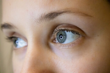 Fototapeta premium Female eyes up close. Blue-eyed European girl looking in colored contact lenses.