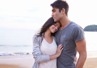 My favorite place is next to you. Cropped shot of an affectionate young couple at the beach.