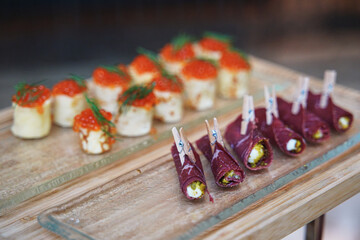 small appetizers with red caviar and meat rolls