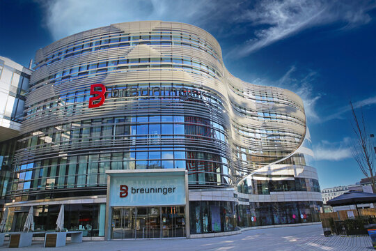 D&uuml;sseldorf, Germany - March 9. 2022: View on building with fully glassed window facade, Breuninger fashion store against blue sky with fluffy clouds