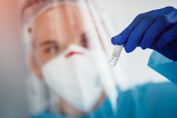Woman doctor holding test tube with covid-19 coronavirus vaccine 