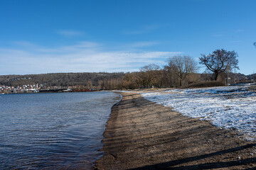 Obraz premium A winter beach covered with snow and a blue sky in the background