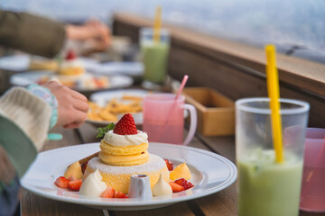 カフェのテラス席でパンケーキを食べる