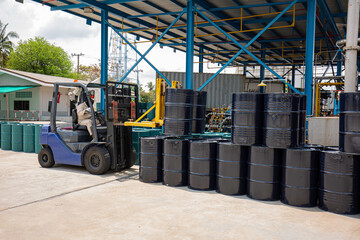 Oil barrels black chemical drums horizontal stacked up rear forklift lifts © chitsanupong