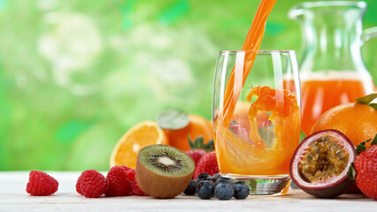 Multivitamin juice pouring into glass. Fresh orange juice with oranges fruit on wooden table.