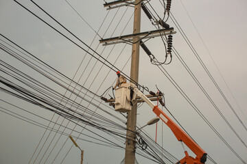 Male workers Installation of high-voltage transmission electricity poles on the crane