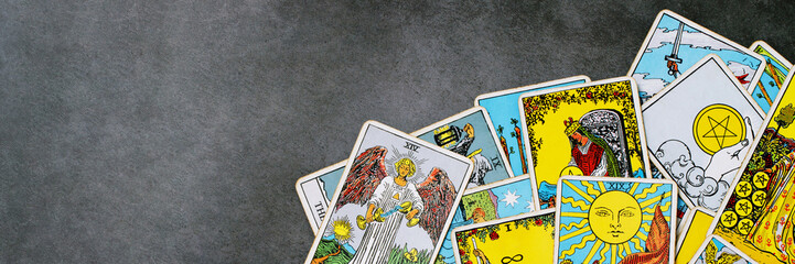 A pile deck of Tarot cards gypsy inspired on a wooden background scattered and haphazardly...