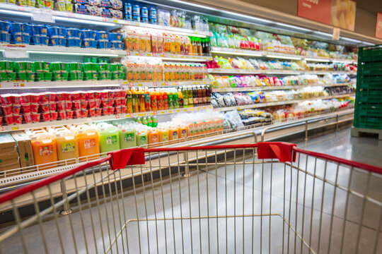 Defocused Blur Buying Cart Shopping Put On At Shelf  At Floor Drink In Supermarket