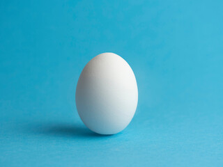 Egg on a blue background. Minimalism. Easter holiday.