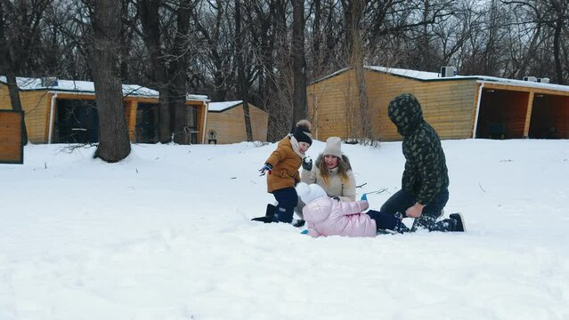 Happy family having fun playing in the snow. Winter entertainment