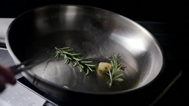 Rosemary and garlic on a heated pan