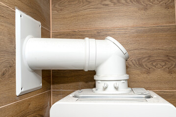 A modern gas boiler for natural gas, installed in a boiler room lined with ceramic tiles, visible...