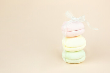 Stack of marshmallows looks like gift with white ribbon bow, French cookie. Macaroons Cakes.