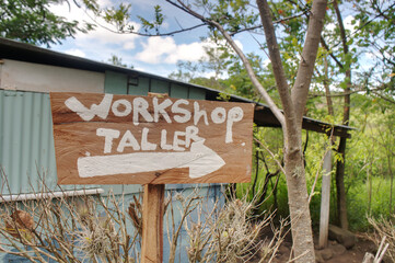 A craft workshop sign written in English and Spanish. Bilingual poor and rural communities concept.