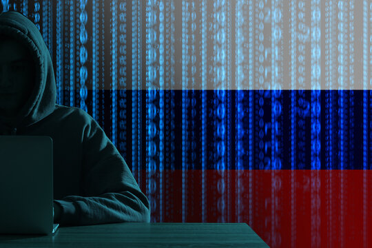 Silhouette of Russian hacker with laptop on dark background with space for text
