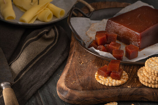 Quince cheese or marmelada is a sweet, thick jelly made of the pulp of the quince fruit. Marmalade in crackers on a kitchen counter. Dulce de membrillo in Spain
