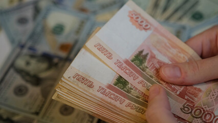 Women's hands hold a pack of Russian ruble banknotes