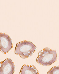 Pattern of agate crystals isolated on beige background,  top view natural slices beautiful gemstone. Agate stone healing crystal, minimal style layout with copy space, beige pink pastel color