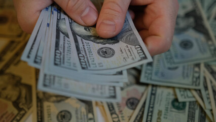 Men's hands count 1000 American one hundred dollar bills