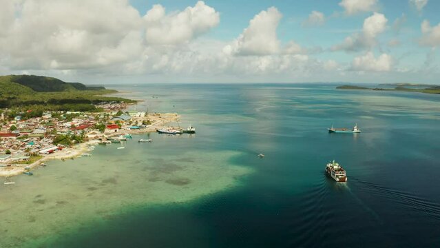 Passenger port with ferries and cargo ships on the island of Siargao,aerial view. Dapa Ferry Terminal. Siargao, Philippines.