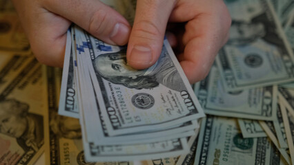 Men's hands count 1000 American one hundred dollar bills