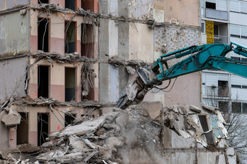 bras de pelle à mâchoires démolissant un bâtiment