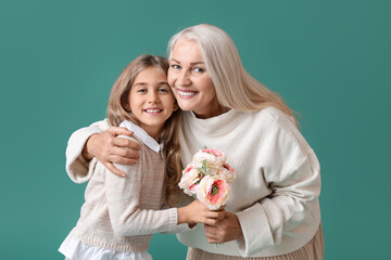 Little girl with flowers and her grandma on green background
