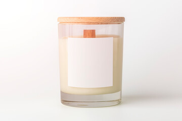 New wax candle in glass with clean label for design. Cozy home decor. Place for text