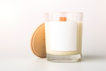 Wax candle in glass with wooden lid and blank label. Cozy home decor. Place for text