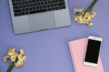Cropped shot or laptop computer keyboard and a small bouquet of flowers. Close up, top view, copy space, background, flat lay.