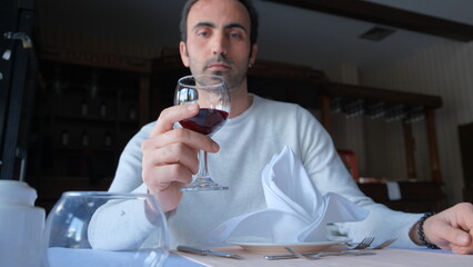 Man drinks wine in minimal luxury restaurant in hotel for summer time. 