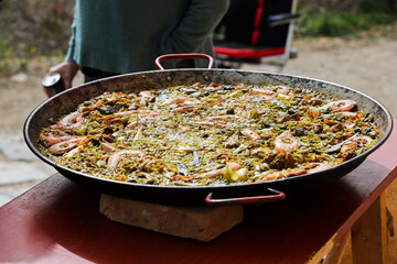 paella in the field, with fire and sunny day