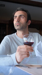 Man drinks wine in minimal luxury restaurant in hotel for summer time. 