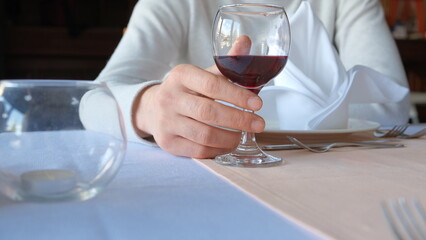 Man drinks wine in minimal luxury restaurant in hotel for summer time. 