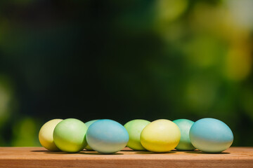 Easter eggs on wooden shelf outdoors. Copy space.