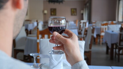 Man drinks wine in minimal luxury restaurant in hotel for summer time. 
