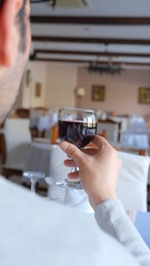 Man drinks wine in minimal luxury restaurant in hotel for summer time. 