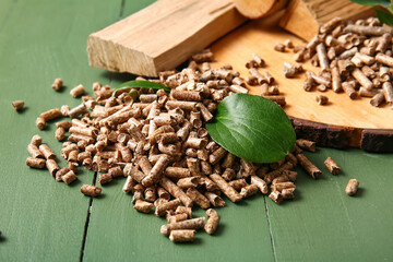 Pile of wood pellets on color wooden background, closeup